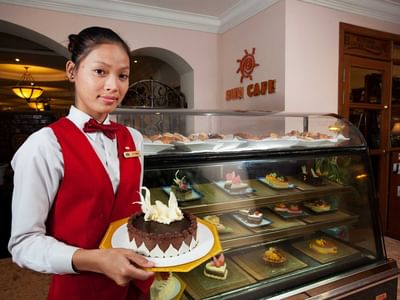 Hotel staff holding a Birthday cake by the counter at Sunway Hotel Phnom Penh