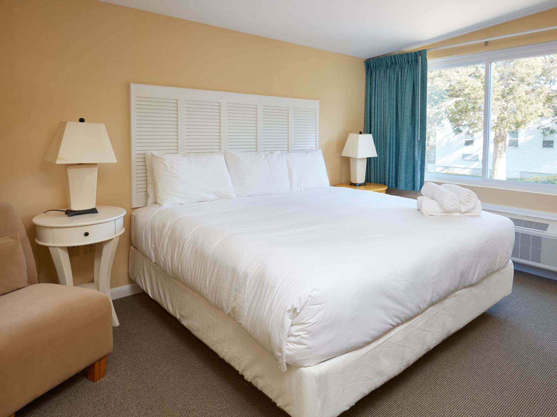 Bed with table lamp by the window in Anika One Bedroom at Breezeway Boutique Hotel