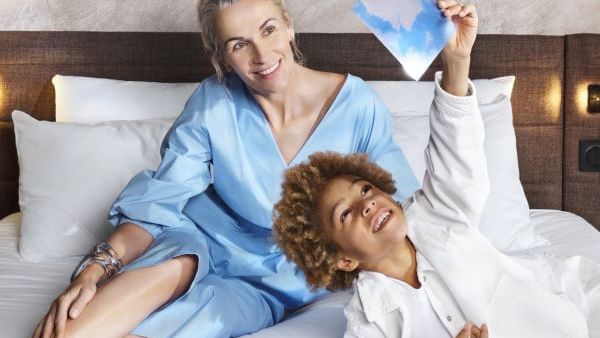 A mom and a son enjoy the comfortable bed in Novotel Perth Langley's room