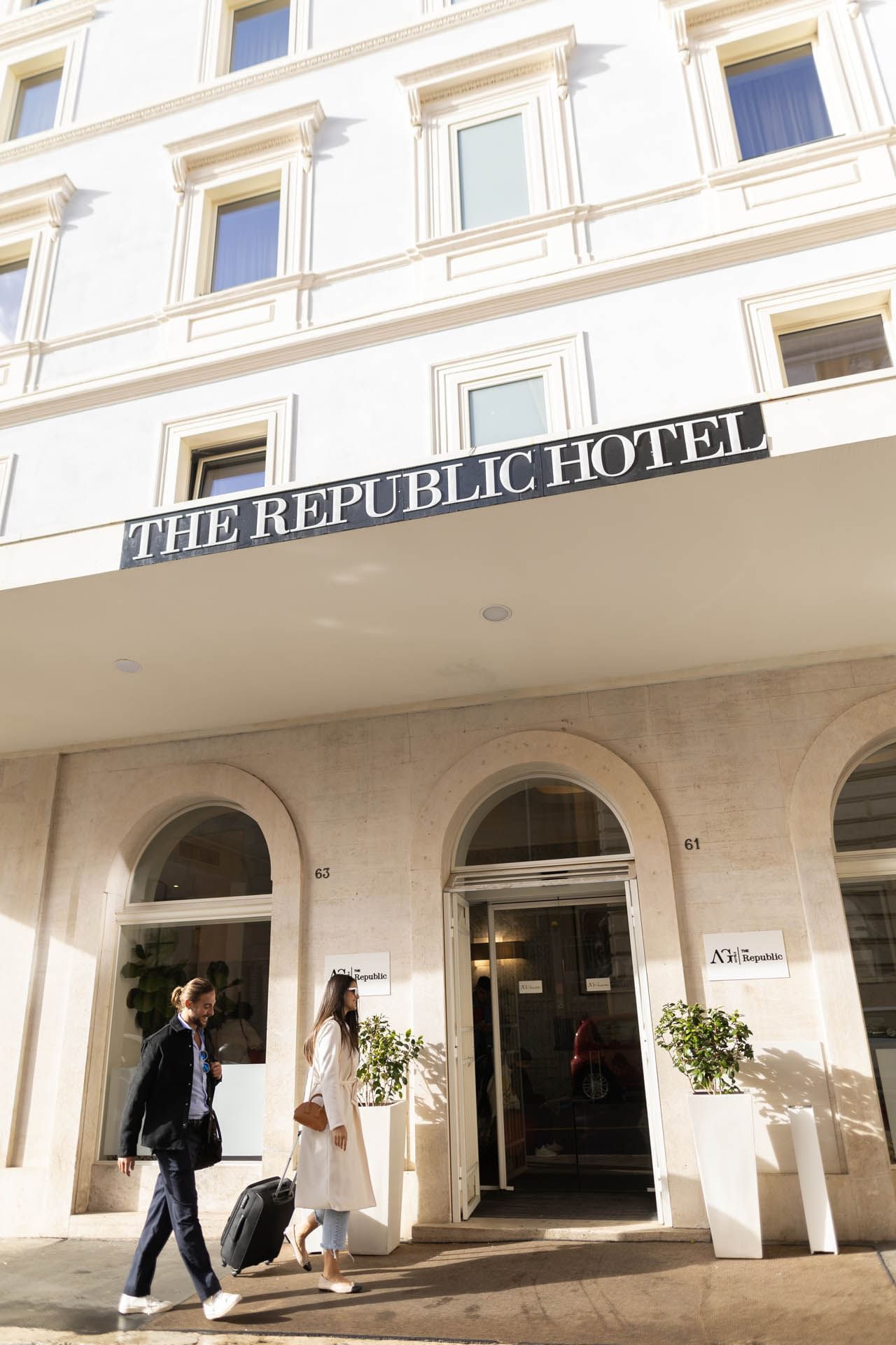 The entrance of The Republic Hotel features elegant arches and a prominent sign displaying the hotel's name.
