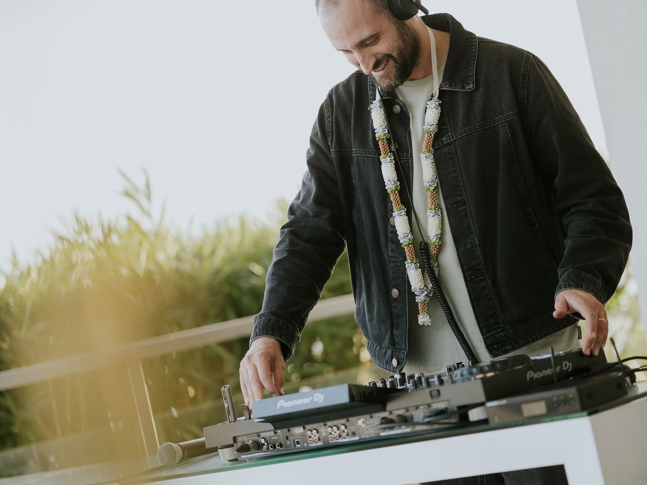 DJ with headphones and equipment on table for sunset happy hour at Hotel Cascais Miragem Terrace.