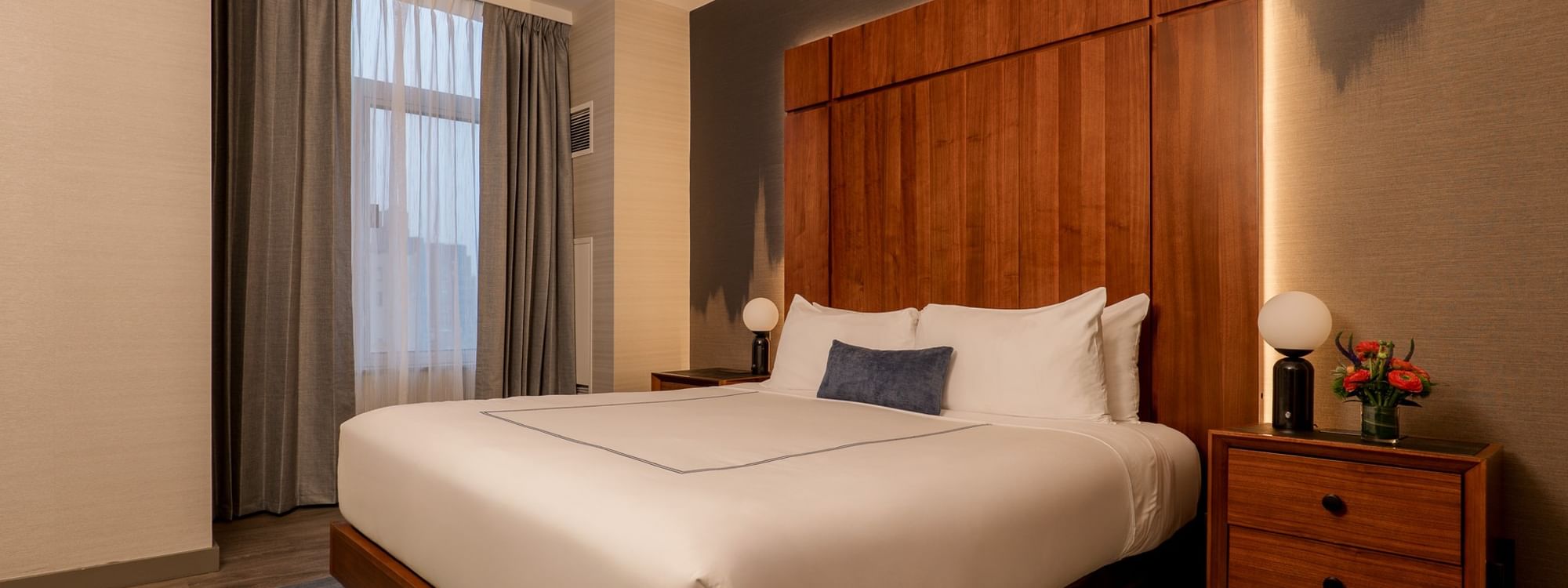 Elegantly furnished Two-Bedroom Manhattan Suite with a large bed and modern decor at Gansevoort Meatpacking NYC.