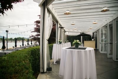 Sunroom terrace with standing cocktail tables and lake view.