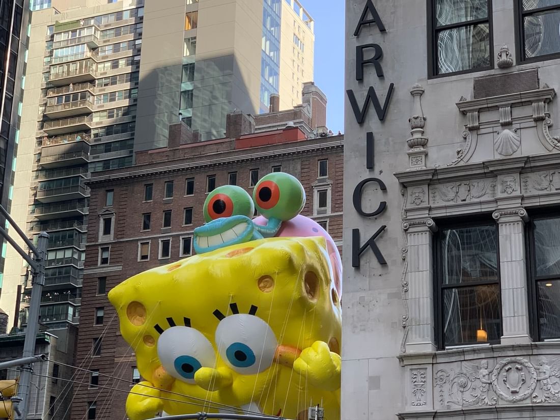 SpongeBob balloon floating by the historic stone facade of the Warwick New York