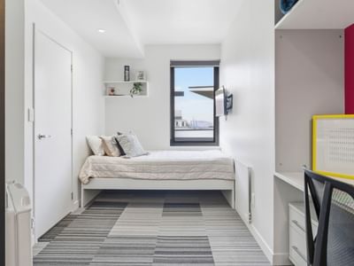 Clean and modern room with desk and bed at UniLodge Auckland City.