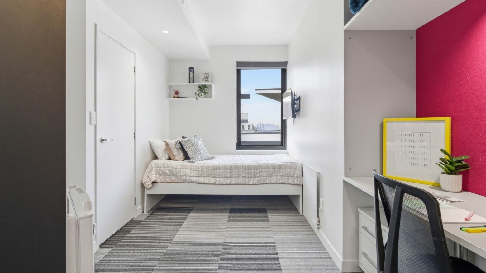 Clean and modern room with desk and bed at UniLodge Auckland City.