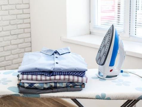 Clothes and an iron on an ironing table at Rheinland Hotel Kollektion