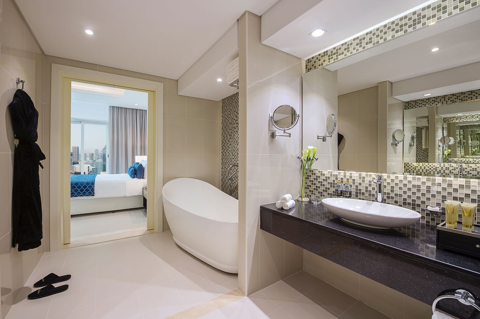 Bathroom vanity with large mirror and bathtub in Three Bedroom Bathroom at DAMAC Maison Distinction