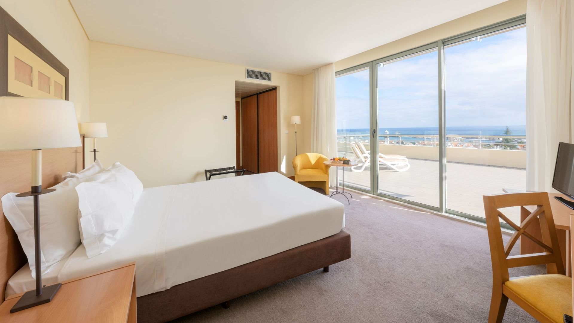 Bed facing the sea in Standards Plus Room at Bensaude Hotels