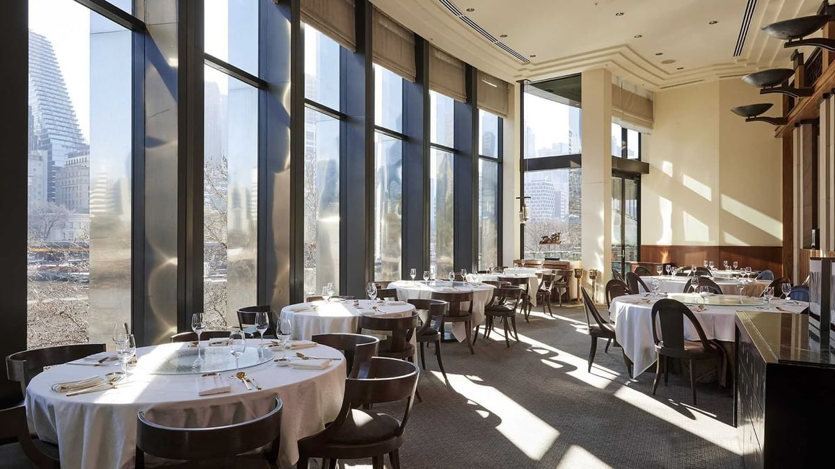 Interior with large windows offering sunlight and city views in Silks Restaurant at Crown Hotel Melbourne