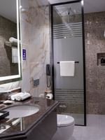 Deluxe Room bathroom with a shower, toilet, and sink at Warwick Hotel & Spa - Jeddah.