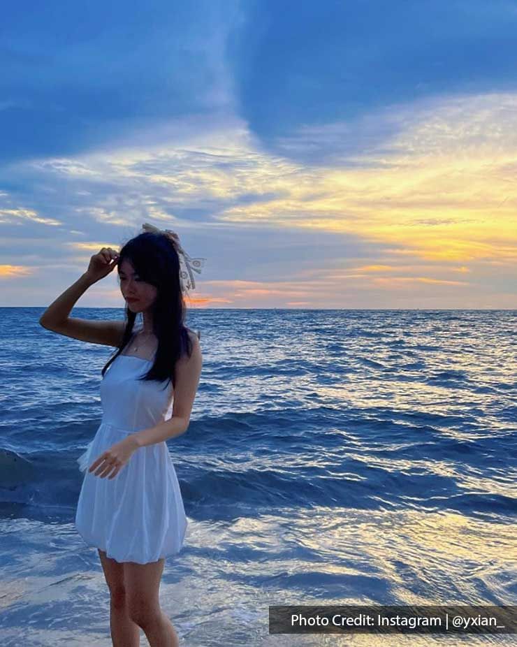 a woman standing on the beach with seaview