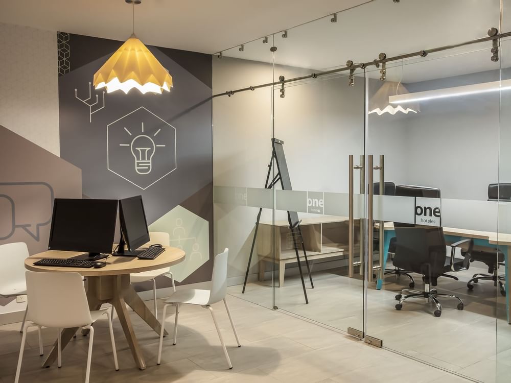 Estaciones de trabajo junto a la sala de reuniones en Business Center, One Hotels
