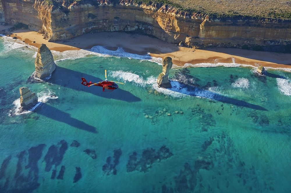A helicopter flying above the beach near Crown Hotel Melbourne