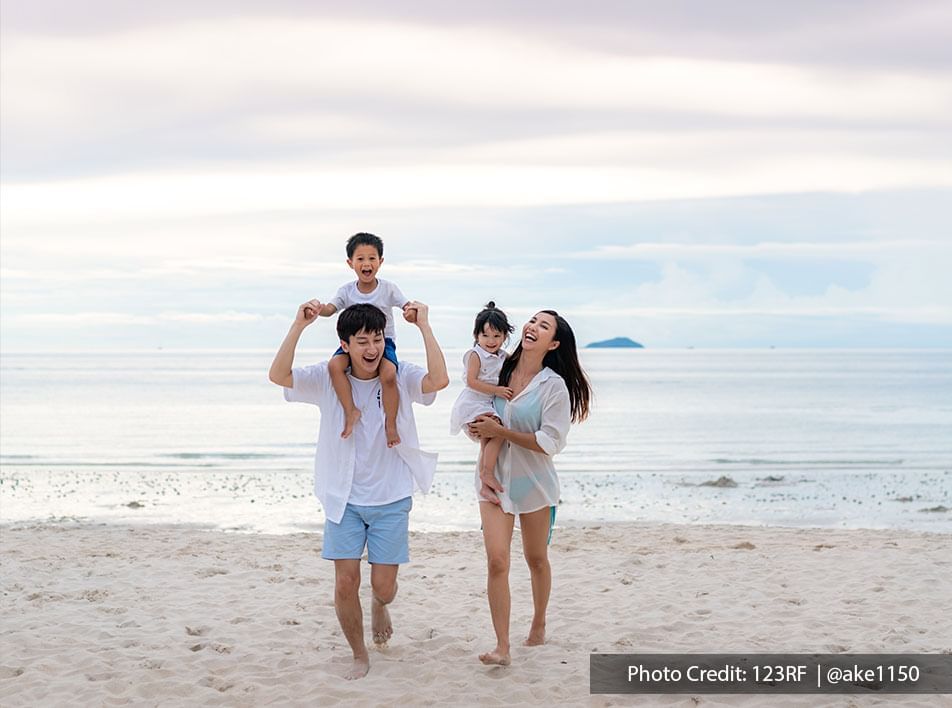Family of four having fun on beach at Lexis Hibiscus
