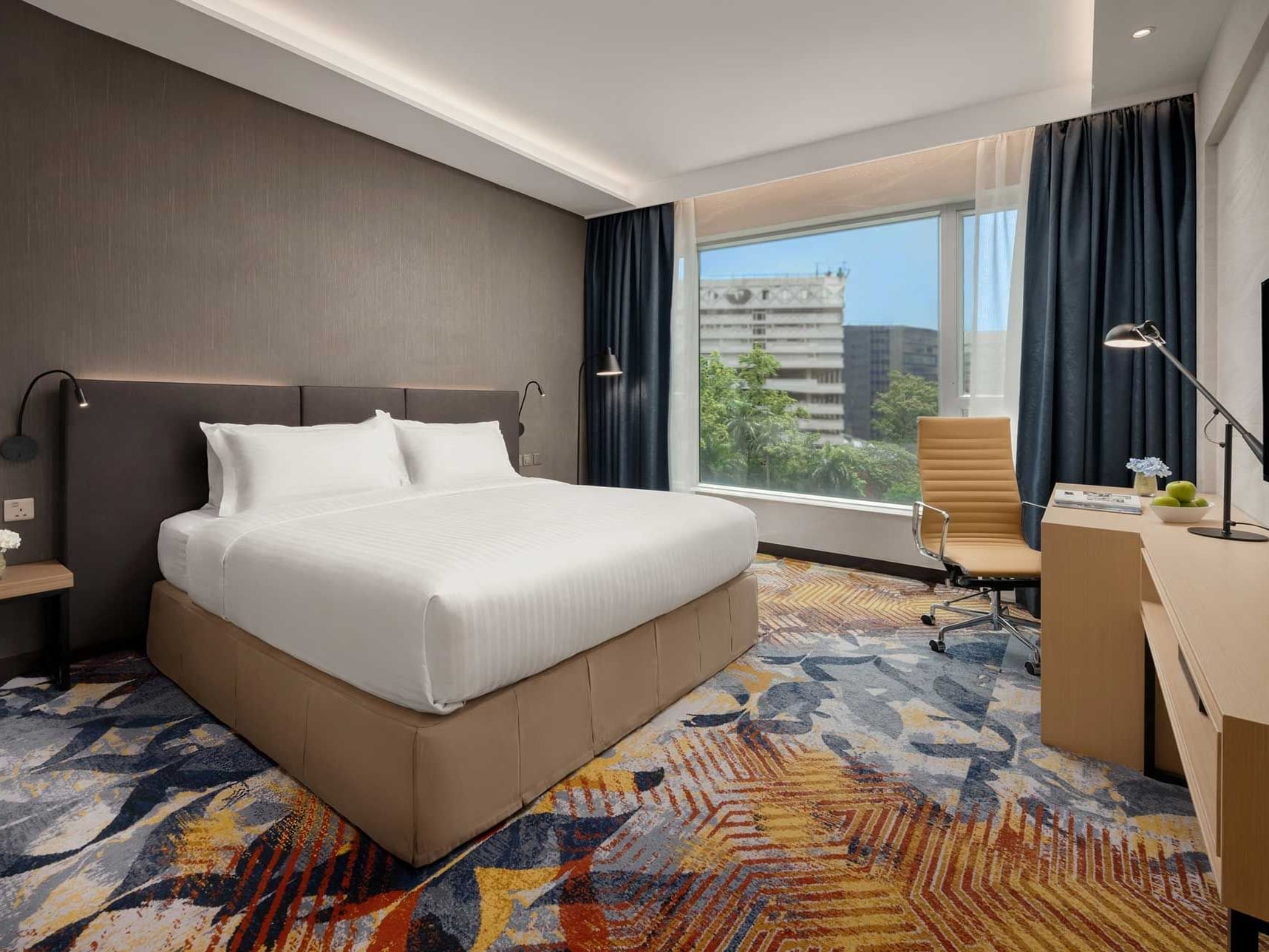 Work desk by the bed in Superior King Room with carpeted floors at Park Hotel Hong Kong