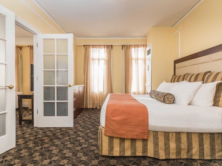 Elegant hotel room with double bed, wooden headboard, and patterned carpet at Pickwick San Francisco.