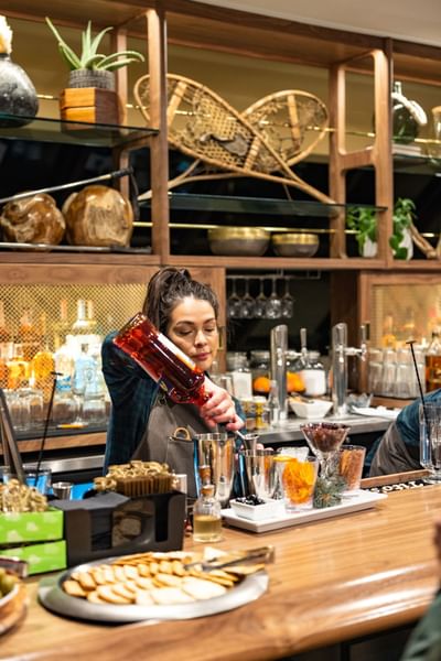 Bartender pouring liquor at José Restaurant bar at Elevation Resort Spa 