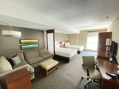 Two queen beds with sitting area and desk in Deluxe Double at MARlNN Place Financial District, 5 star hotels in Panama