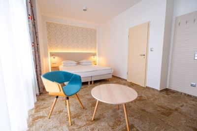 Executive Room with small table, chair and double bed with wall lamps at Metropol Hotel
