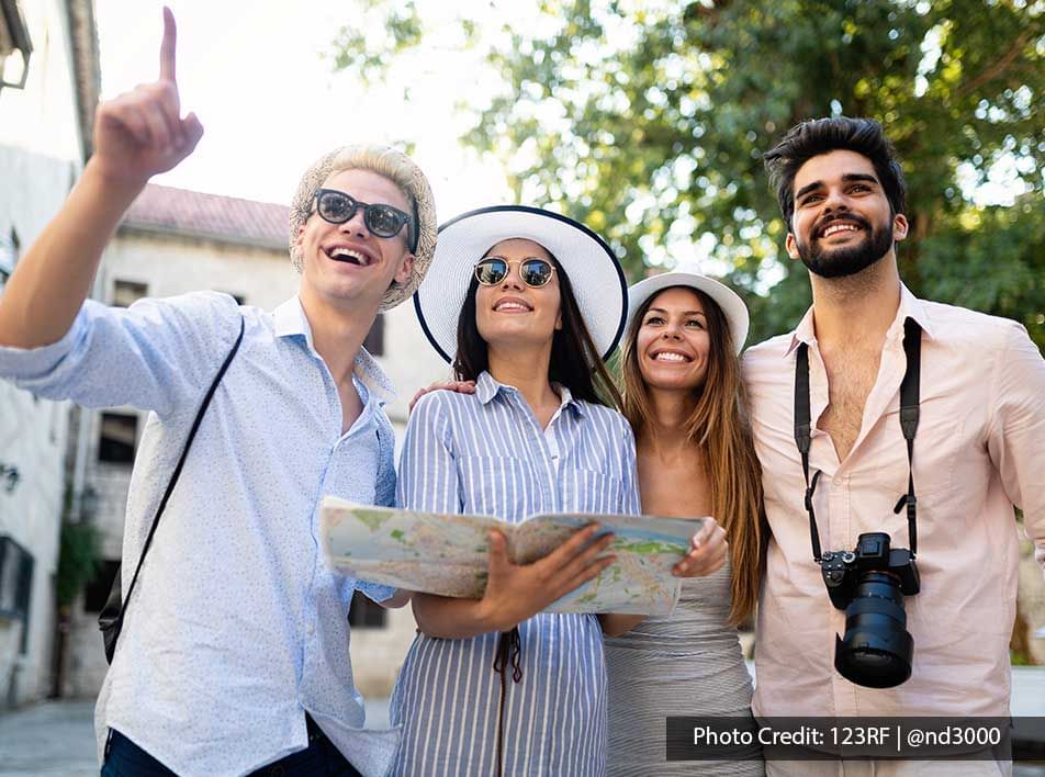 Group of travelers navigating through urban street with one person holding a map - Lexis Port Dickson