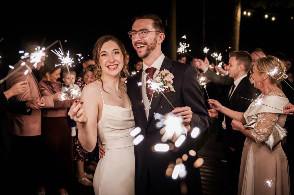 Couple with sparklers at their wedding at Gorse Hill in Surrey