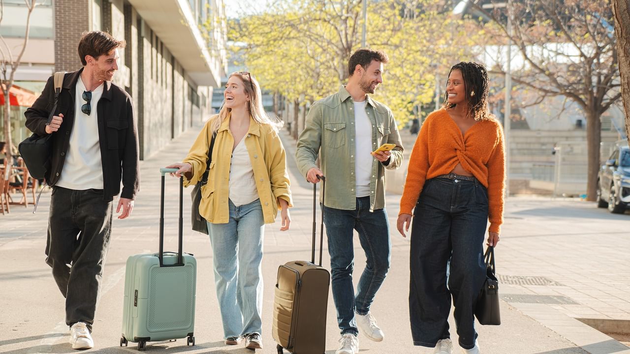 Young people with luggage walking by street in Calgary