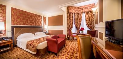 Large bed, comfy sofa & work desk with TV in Deluxe King Room at Grand Visconti Palace