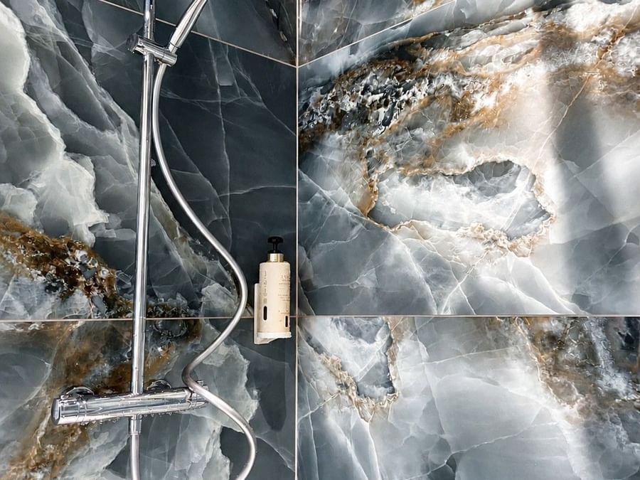 Salle de bain élégante avec douche et carrelage en marbre à l'Osmo Hôtel à Chantepie.
