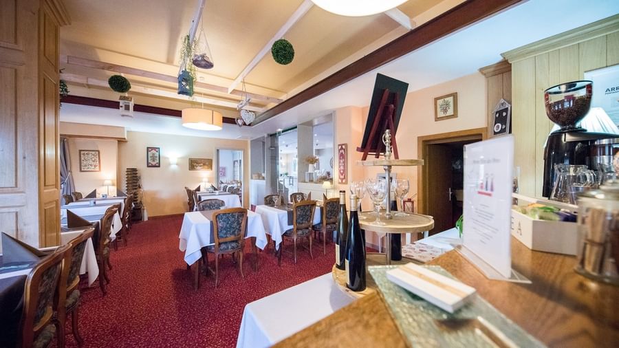 Dining tables set up in the restaurant at Le Kastelberg