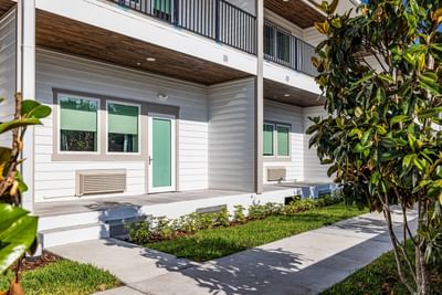 Exterior of apartment building with walkway and sidewalk at Grant Street Inn in Dunedin FL
