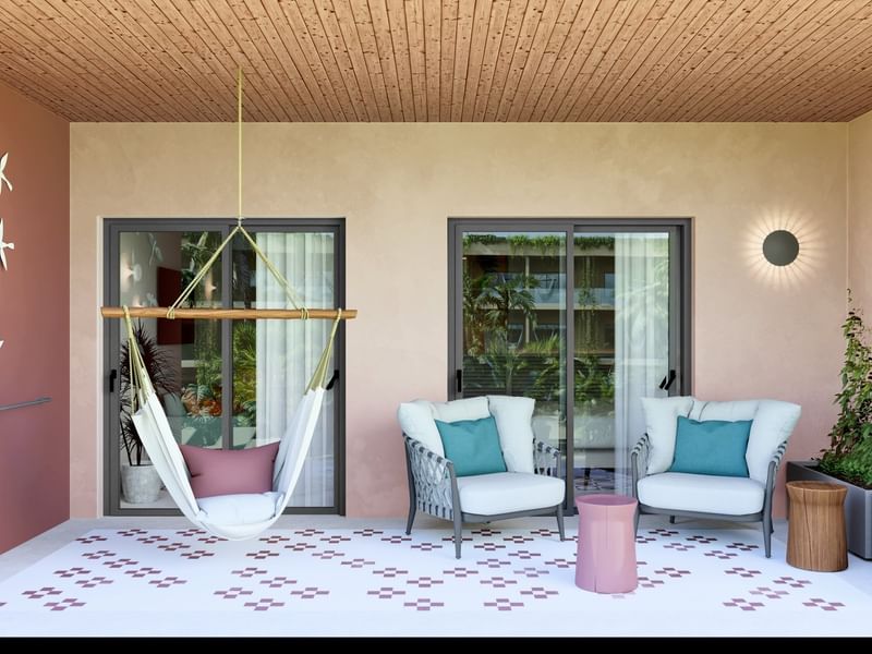 Junior Suite Pool Level vibrante con balcón, hamaca y sillones lounge en Fiesta Americana Funeeq Punta Cana