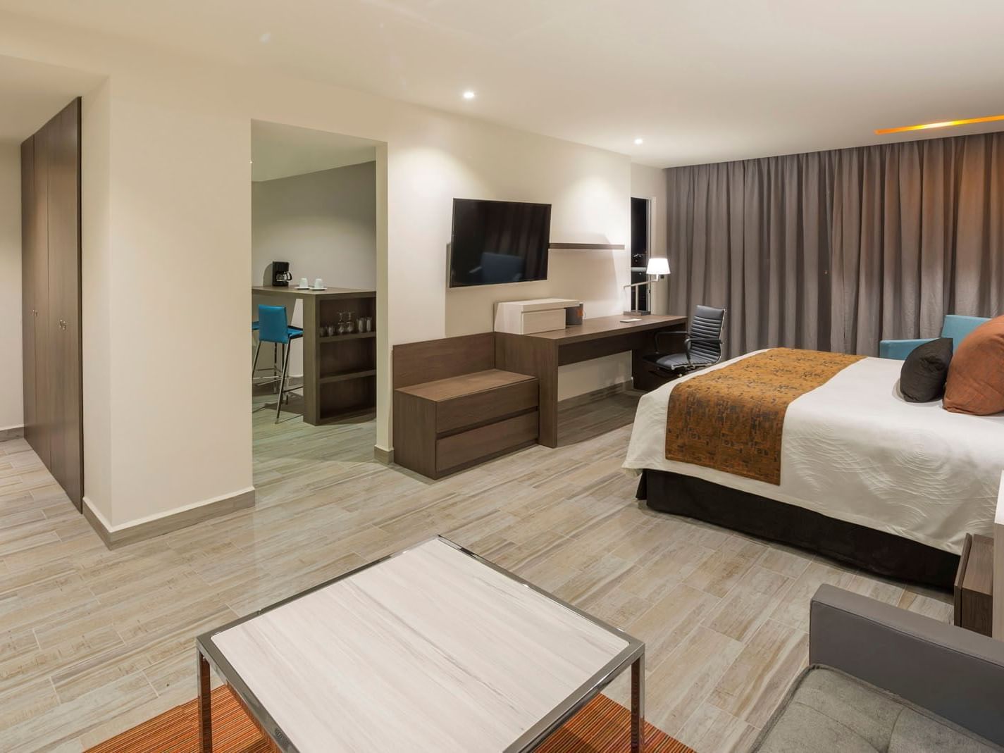 King Junior Suite with a living area, work desk, and a glimpse into a private kitchenette bar at Real Inn Celaya