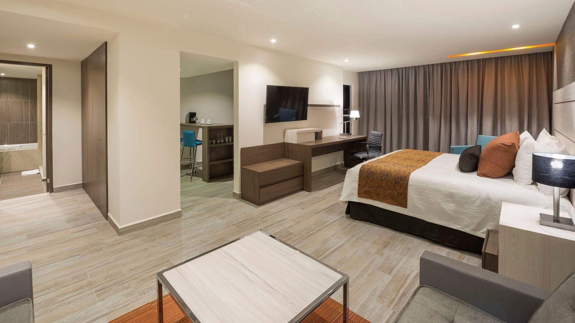 King Junior Suite with a living area, work desk, and a glimpse into a private kitchenette bar at Real Inn Celaya