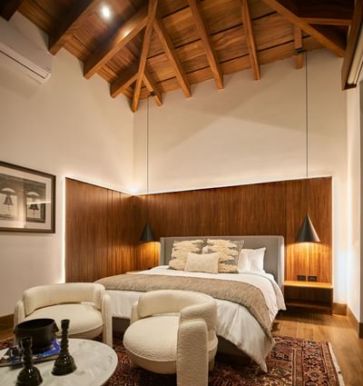 Luxurious bedroom with a high vaulted ceiling and a wooden headboard at Singular Signature Residences
