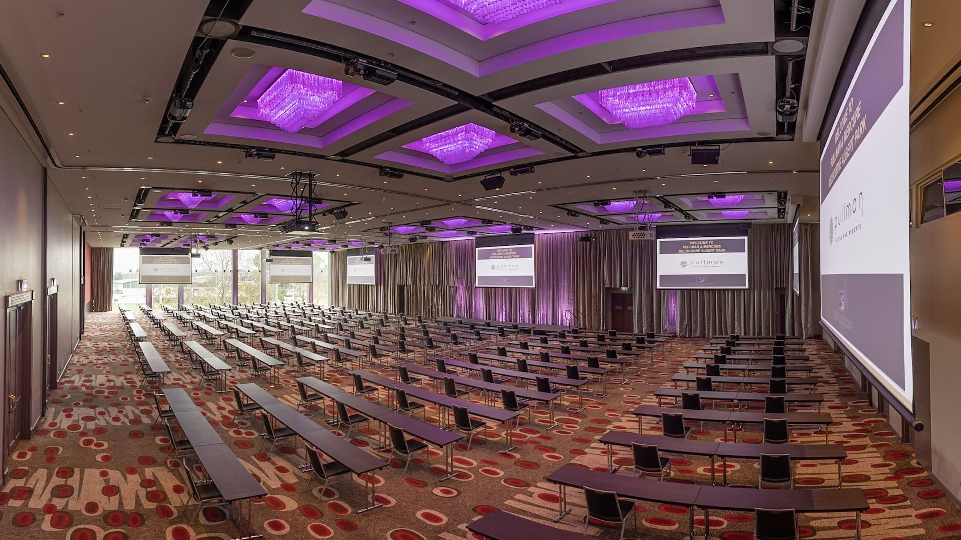 Classroom set-up in Grand Ballroom with screens and carpeted floors at Pullman Albert Park