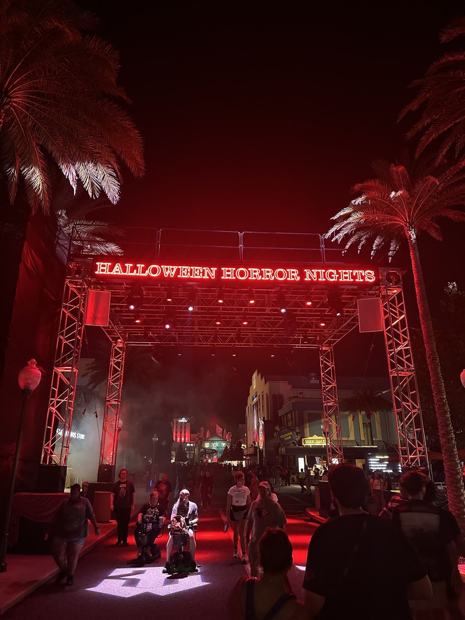 Tall scaffolding that reads Halloween Horror Nights in red at night.