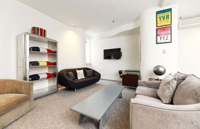 The first-class suite living area, complete with stylish couches and captivating airport and geographic art.