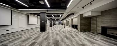 Spacious conference room with modern lighting, gray patterned flooring and black pillars at Hotel Nodo
