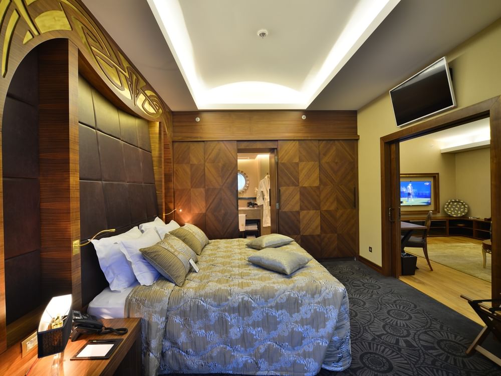 Patterned bed by a wood wardrobe under a recessed ceiling light in Ankara Suite with Terrace at Warwick Ankara