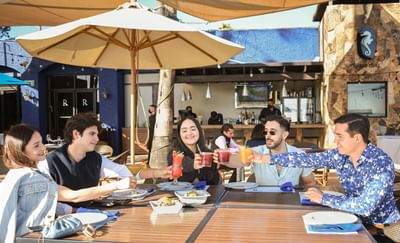 Guests toasting in an outdoor dining area, Hotel Coral y Marina