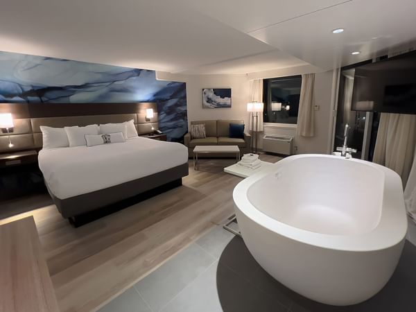 Hotel guestroom with king bed and soaker tub