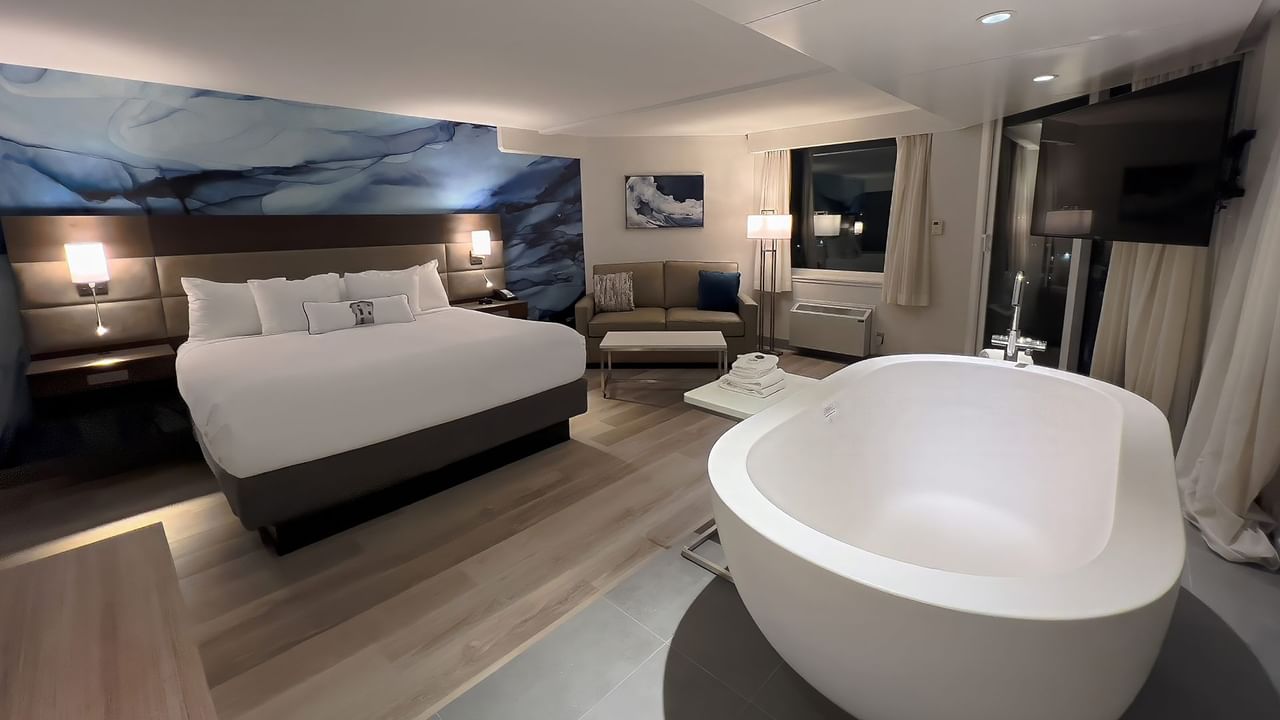 Hotel guestroom with king bed and soaker tub