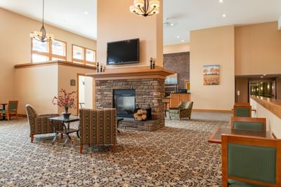 Bright lounge area featuring wooden accents, stone fireplace, and plush seating at White River Inn and Suites