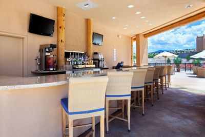 Outdoor bar area at Seasonal Pool Bar, Hilton Santa Fe Buffalo Thunder, with high stools and scenic views