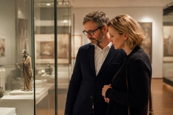 A couple exploring museum exhibits together, looking at displays and artefacts.