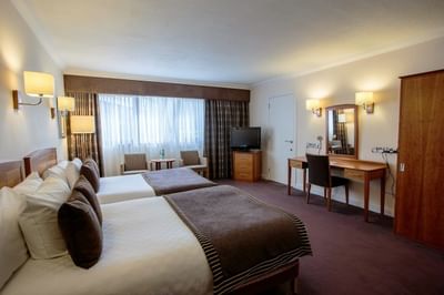 Accessible Room with two comfortable beds, a TV and a wooden table with a mirror at The Aberdeen Altens Hotel