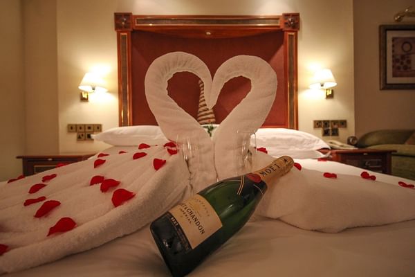 Champagne and rose petals on a bed at Kigali Serena Hotel
