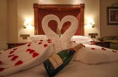 Champagne and rose petals on a bed at Kigali Serena Hotel
