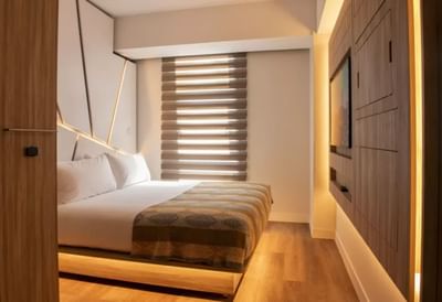 Standard Queen Room with a king-sized bed, stylish wooden furniture, and ambient lighting at Hotel Nodo